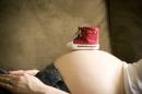Бременна жена с бебешка обувка