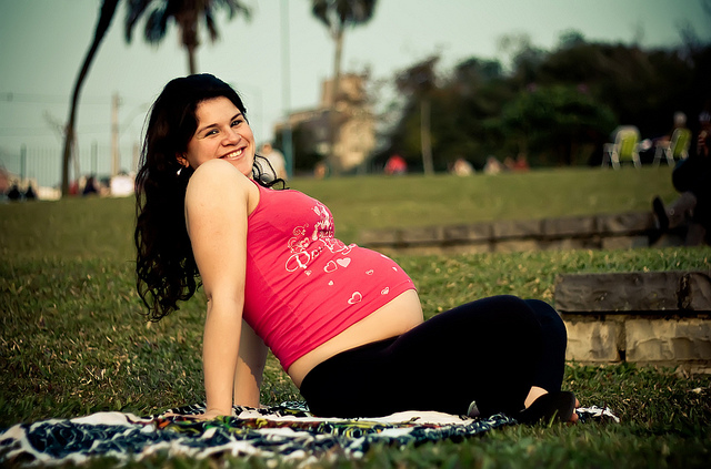 Бременна, седнала на поляна