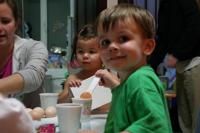 Майка и деца боядисват яйца